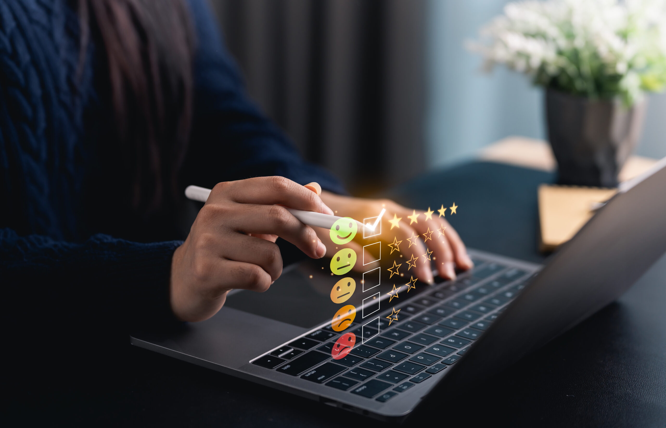 Why Sarbazo closeup hand woman uses stylus laptop generate feedback symbols highlighting creativity engagement modern workspace setting scaled